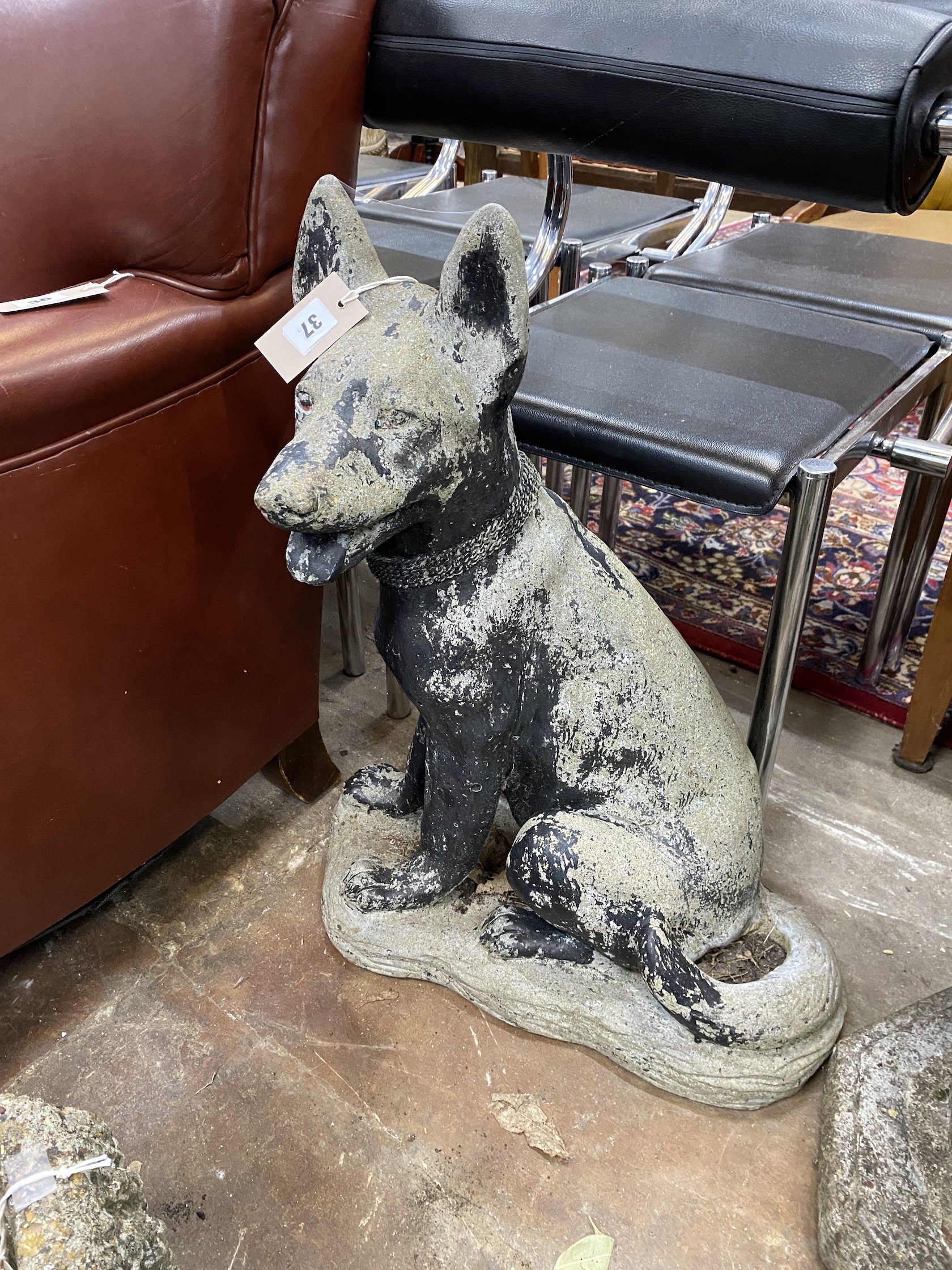 A reconstituted stone garden ornament modelled as an Alsatian puppy, height 66cm